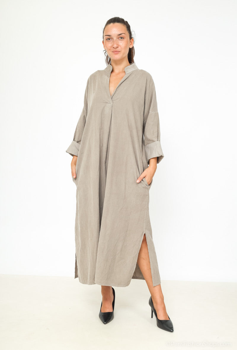 Woman wearing a long beige dress on a white background