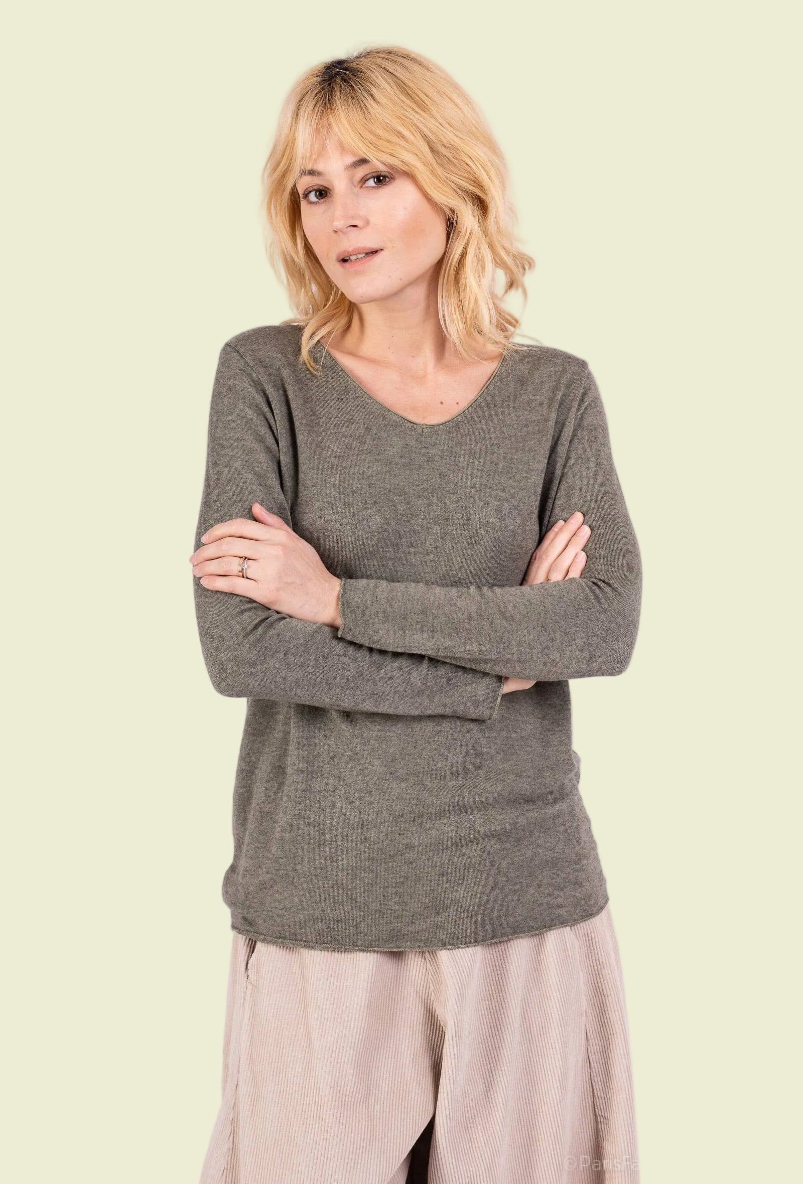 Woman wearing a khaki top and beige pants