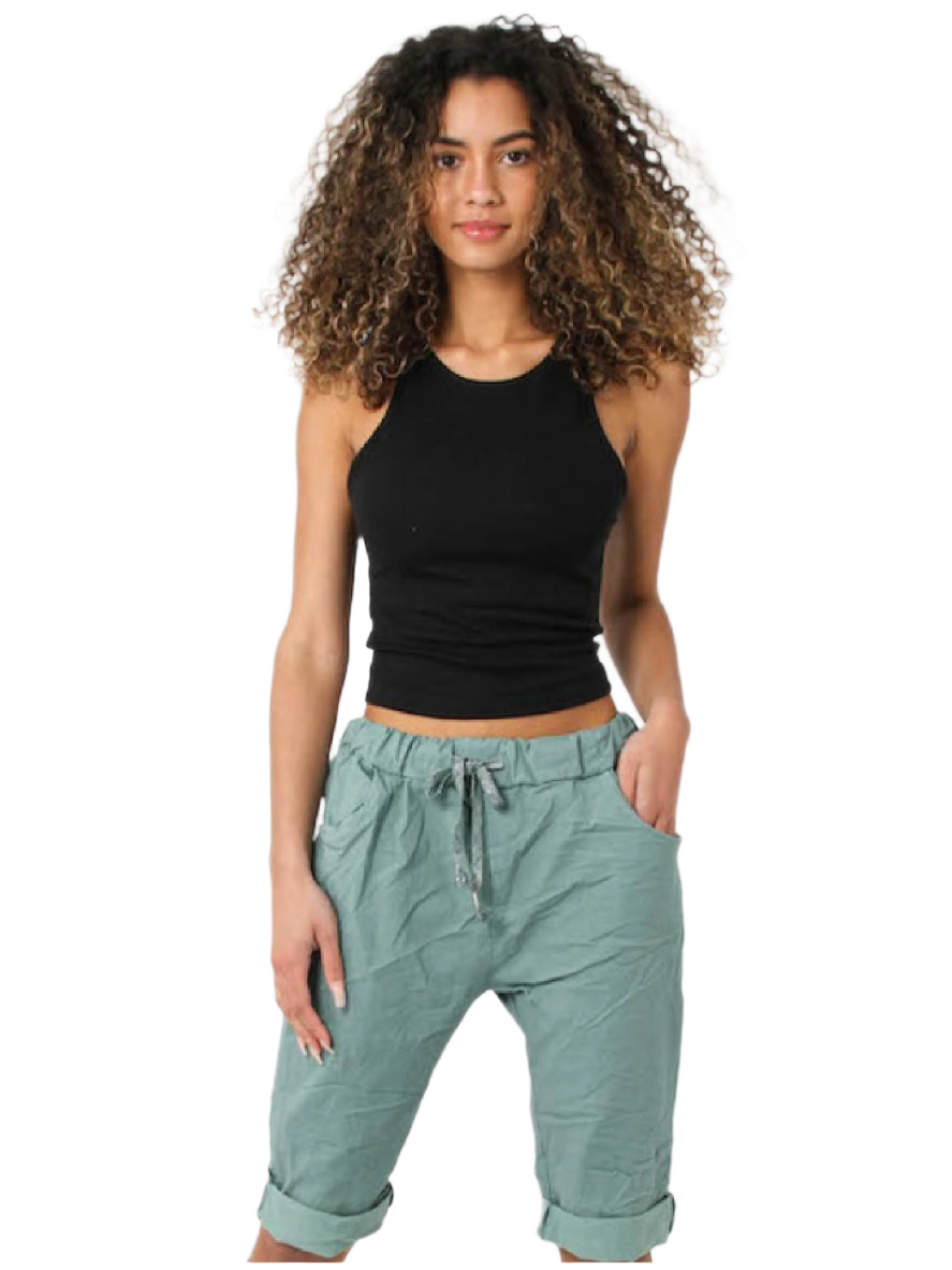 A woman standing, wearing beige Bermuda shorts with side pockets and a black sleeveless top.
