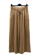 Beige wide-leg pants on a hanger against a white background