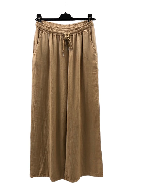 Beige wide-leg pants on a hanger against a white background