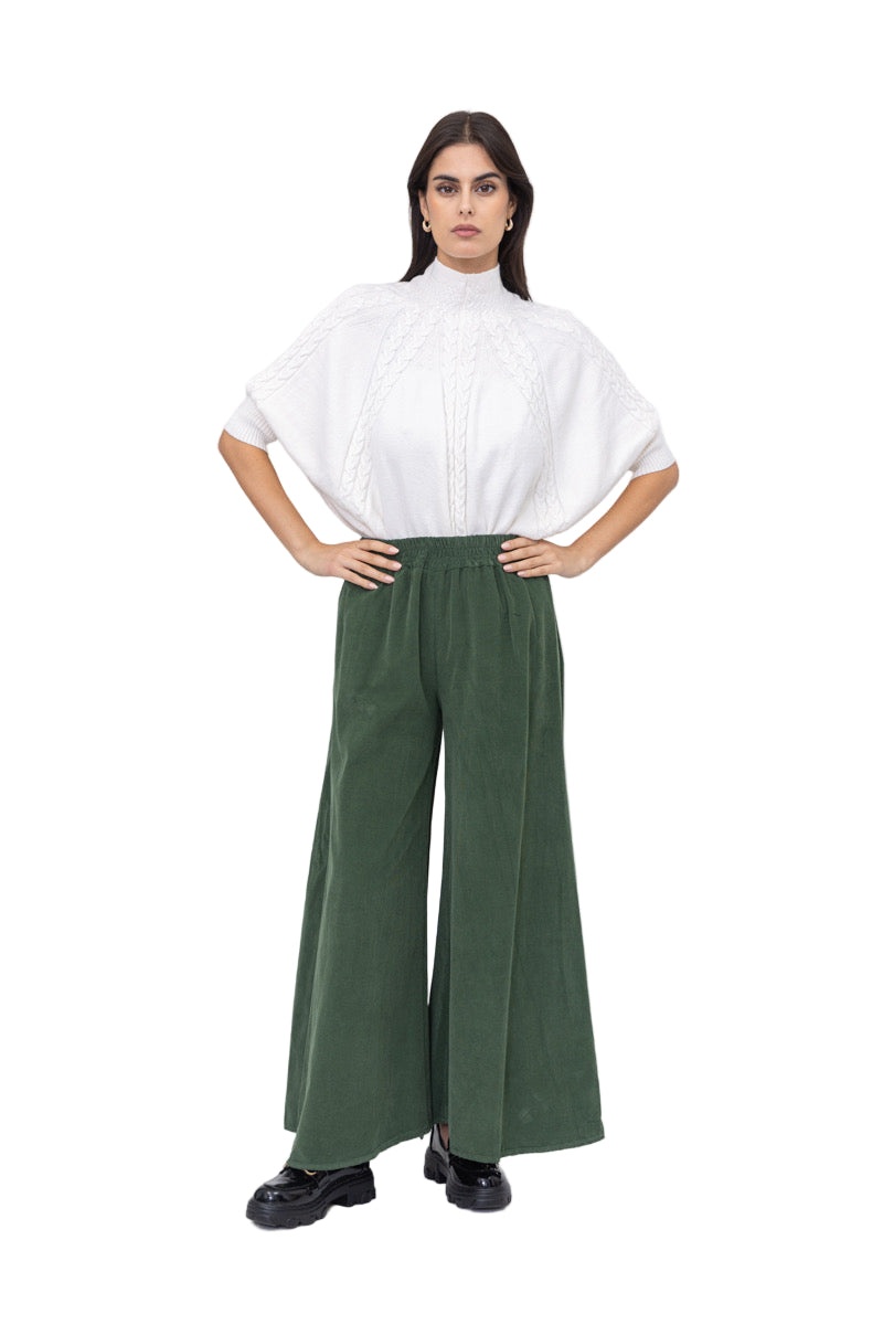 Woman wearing a white top and green pants on a white background