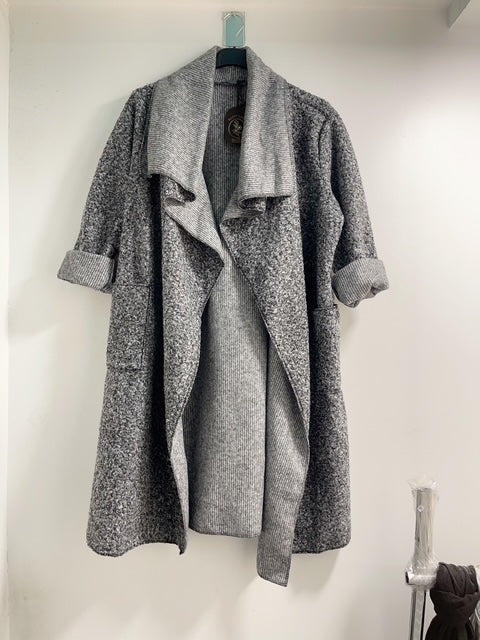 Gray coat hanging on a rack against a white wall