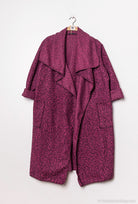 Purple coat on a hanger against a white background