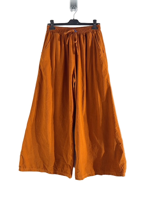 Orange wide-leg pants on a hanger against a white background