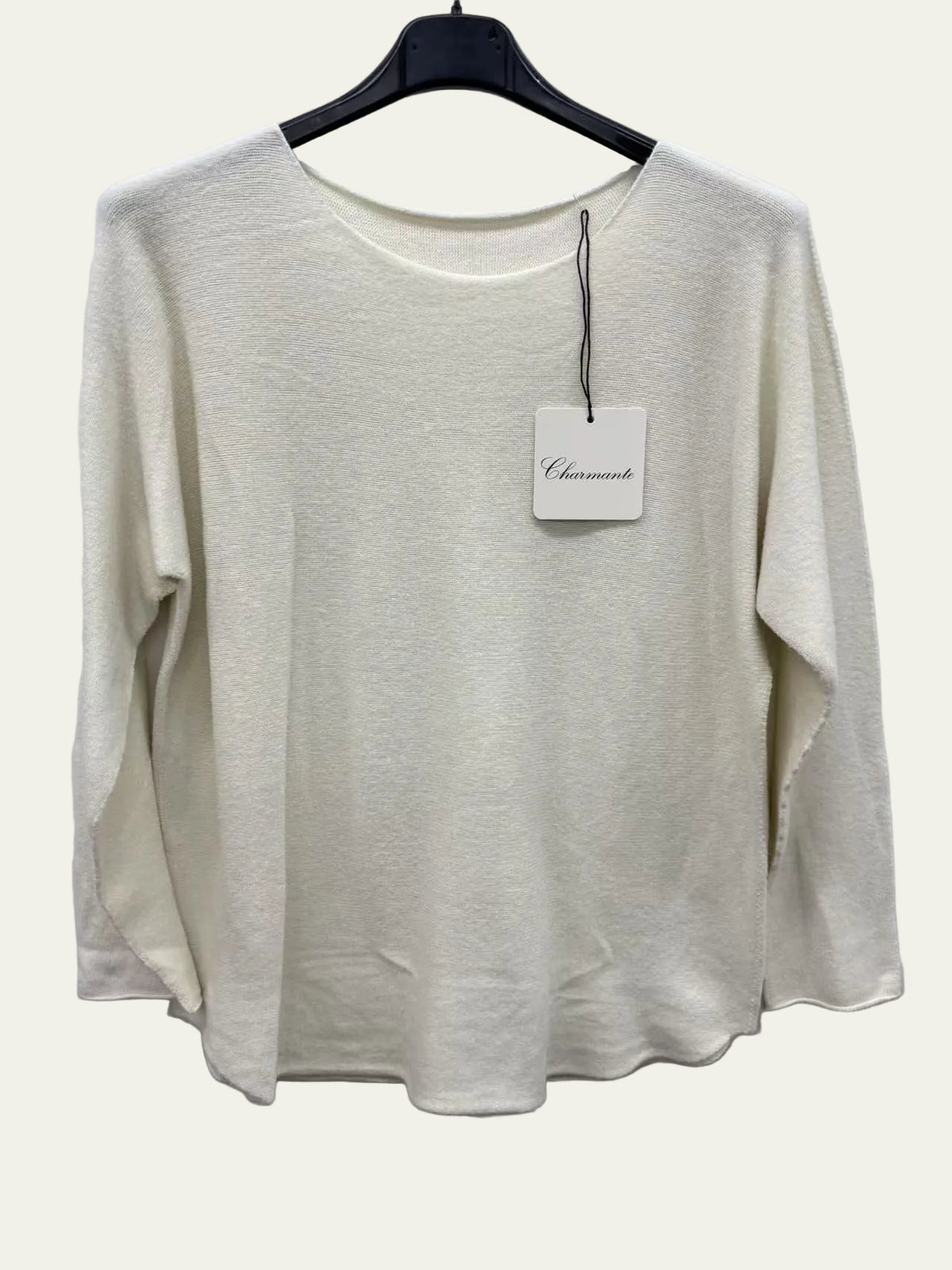 Beige sweater on a hanger with a tag against a white background