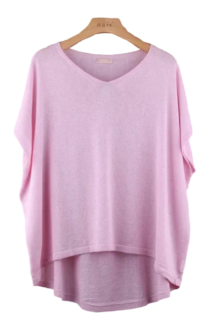 Pink top on a hanger against a tiled wall background