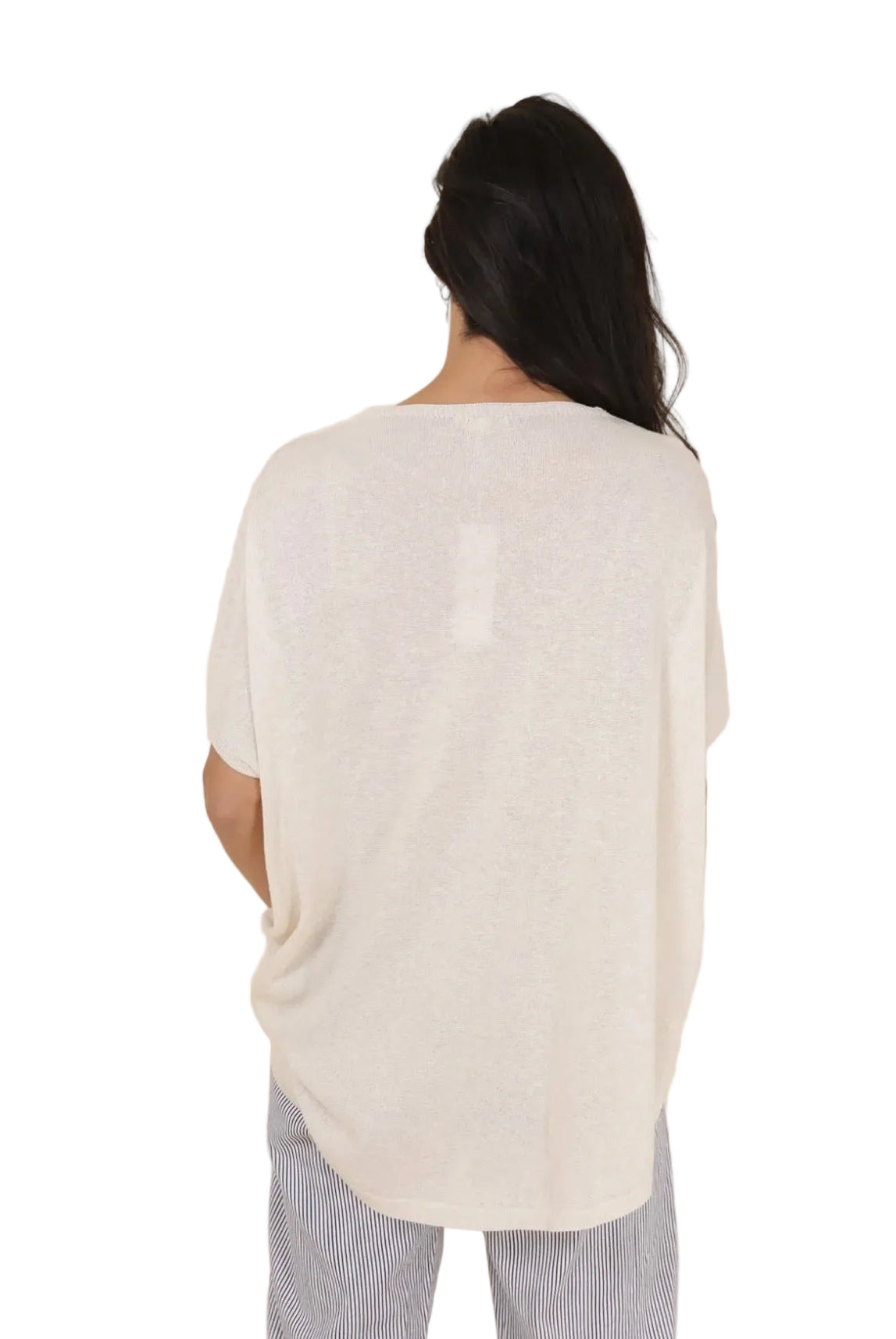 Person wearing a white sweater against a beige background