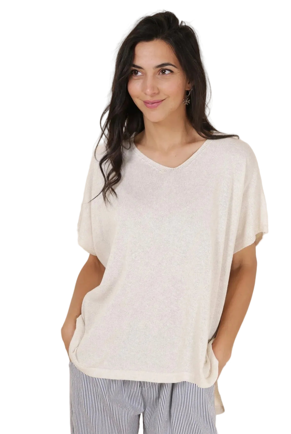 Woman wearing a loose-fitting white top with a neutral background