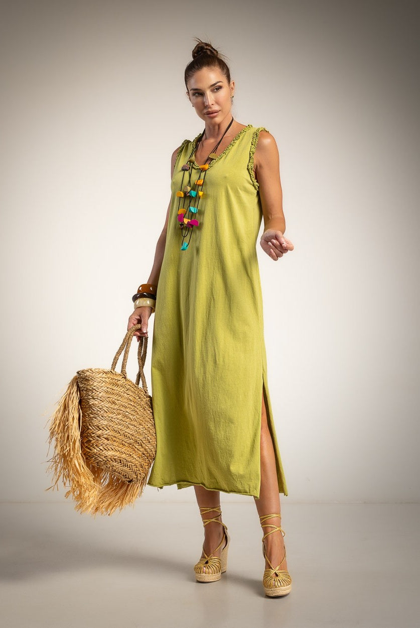 A woman modeling a sleeveless lime green midi dress wit side slits