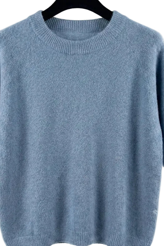Light blue sweater on a hanger against a white background