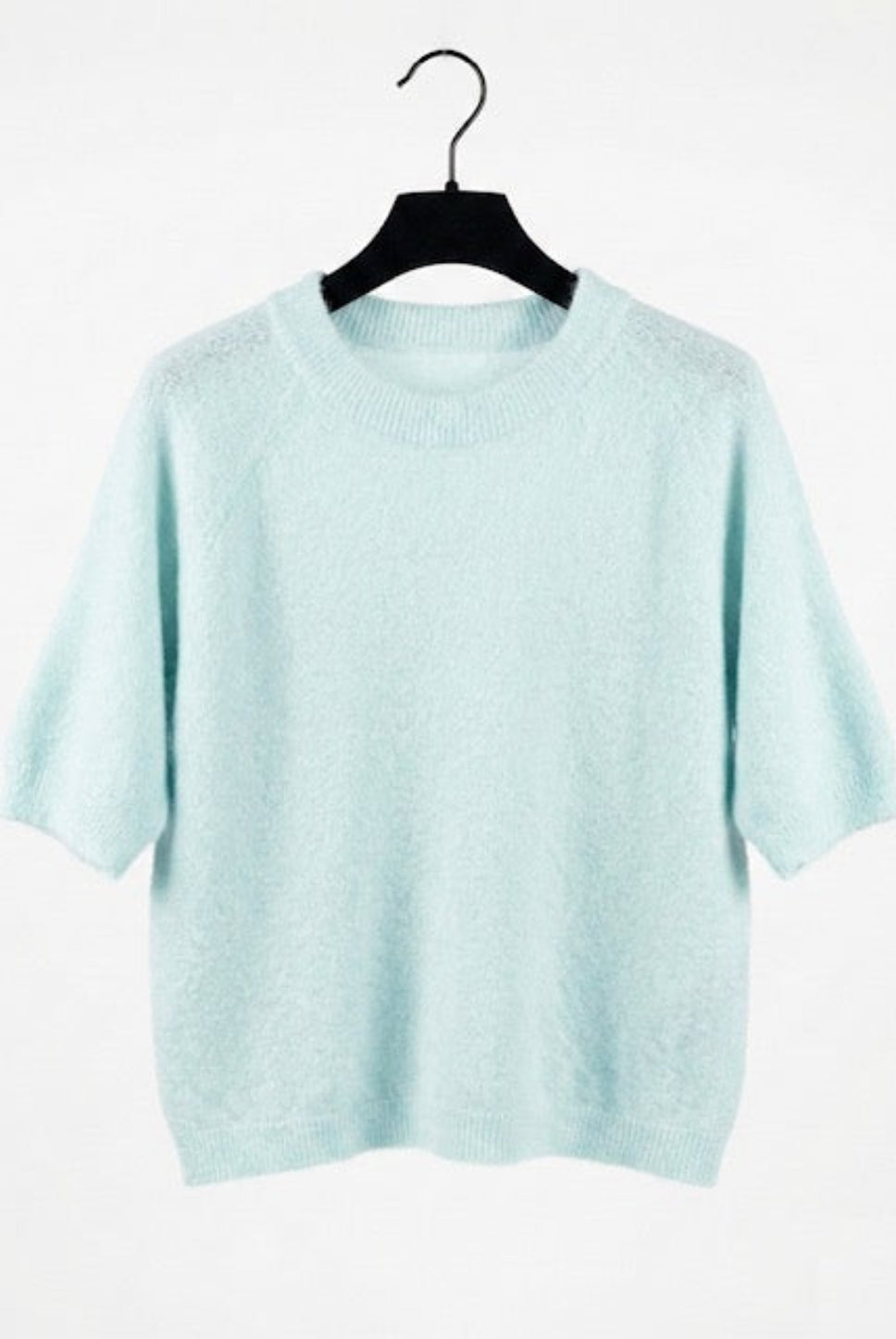 Light blue sweater on a hanger against a white background