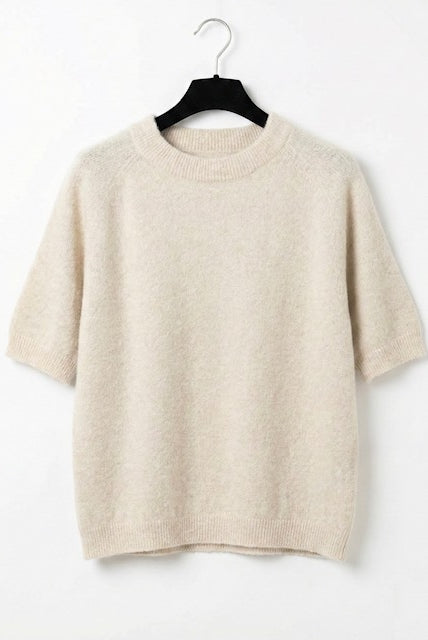 Beige sweater on a hanger against a white background