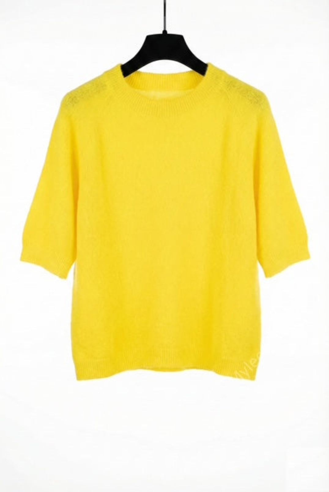 Yellow sweater on a black hanger against a white background