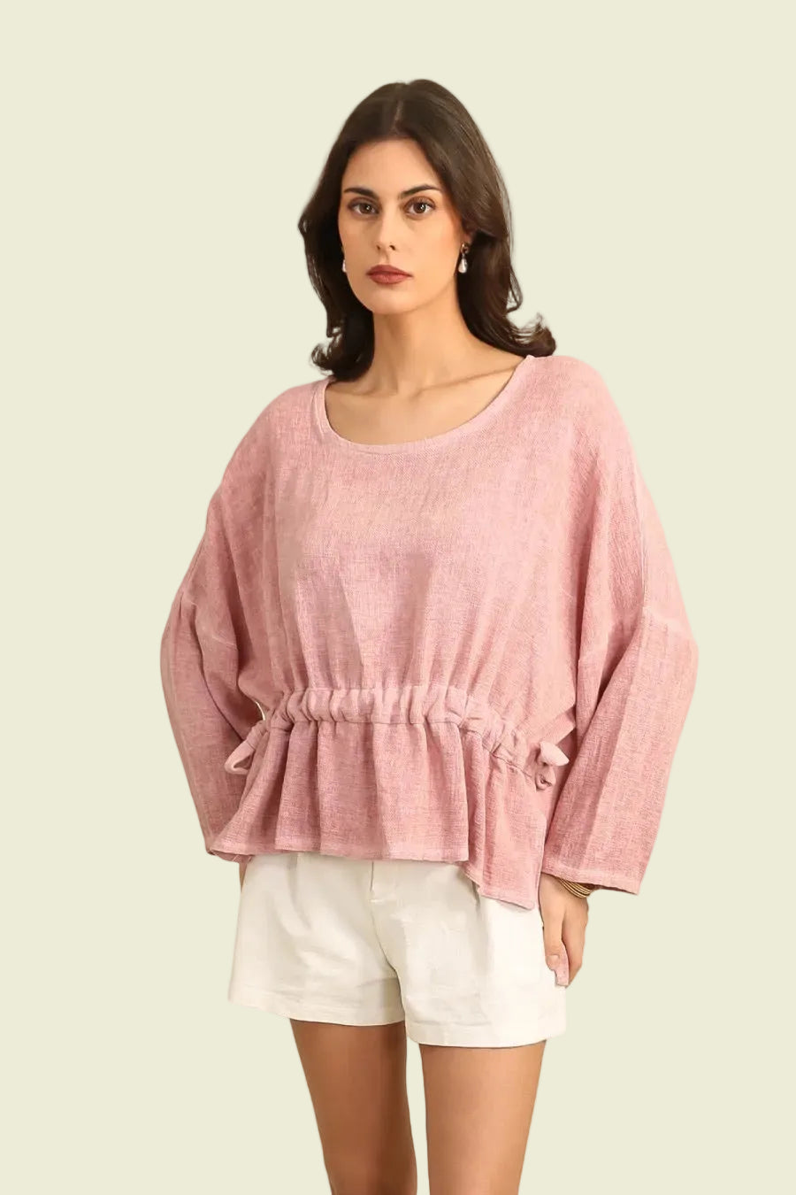 Woman wearing a pink top and white shorts on a white background
