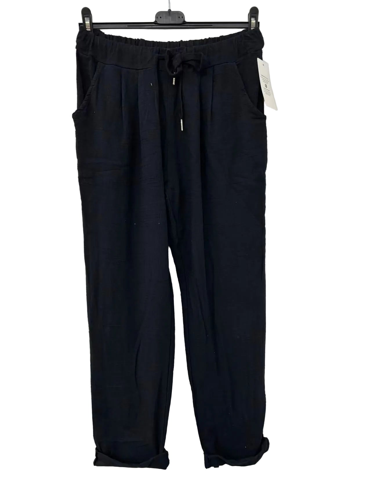 Black pants on a hanger against a white background