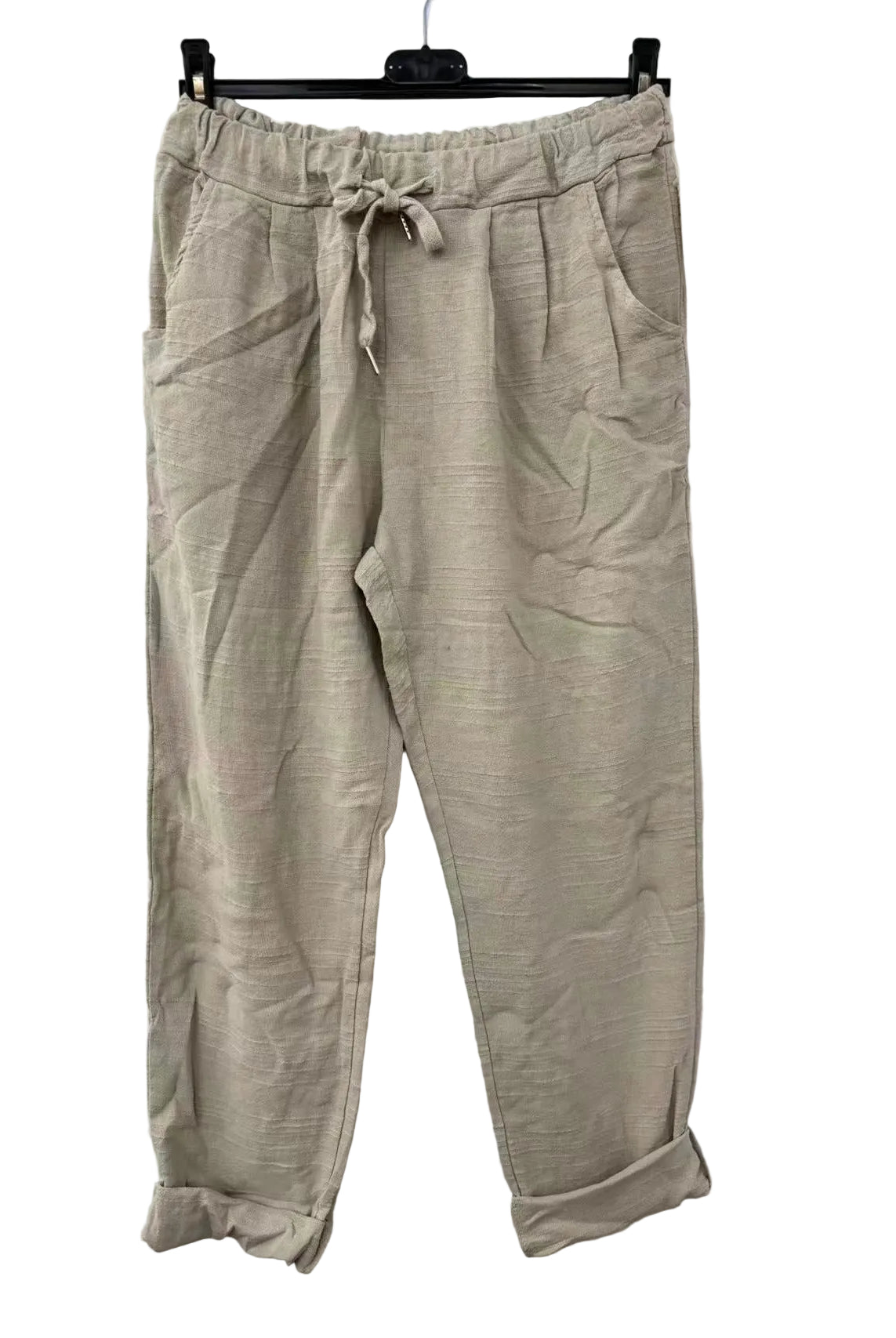 Beige pants on a hanger against a white background