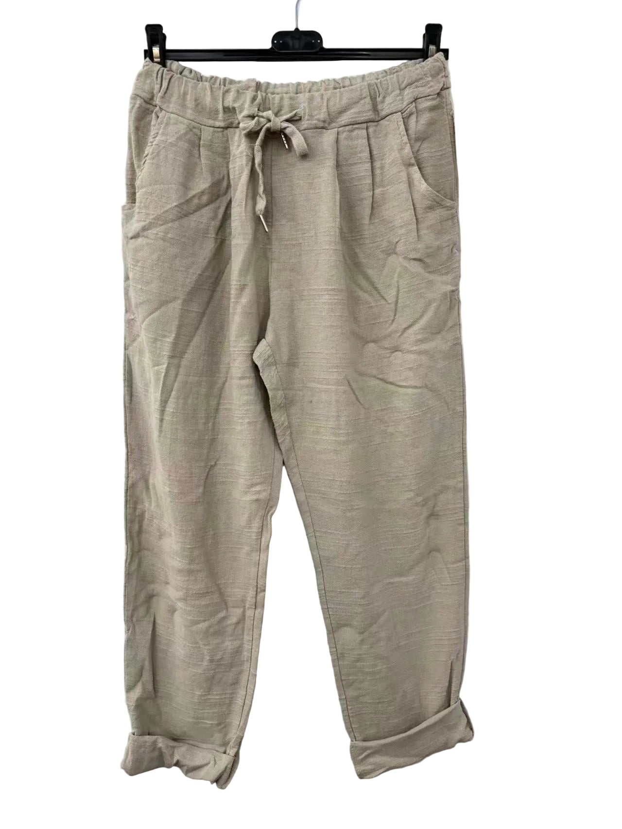 Beige pants on a hanger against a white background