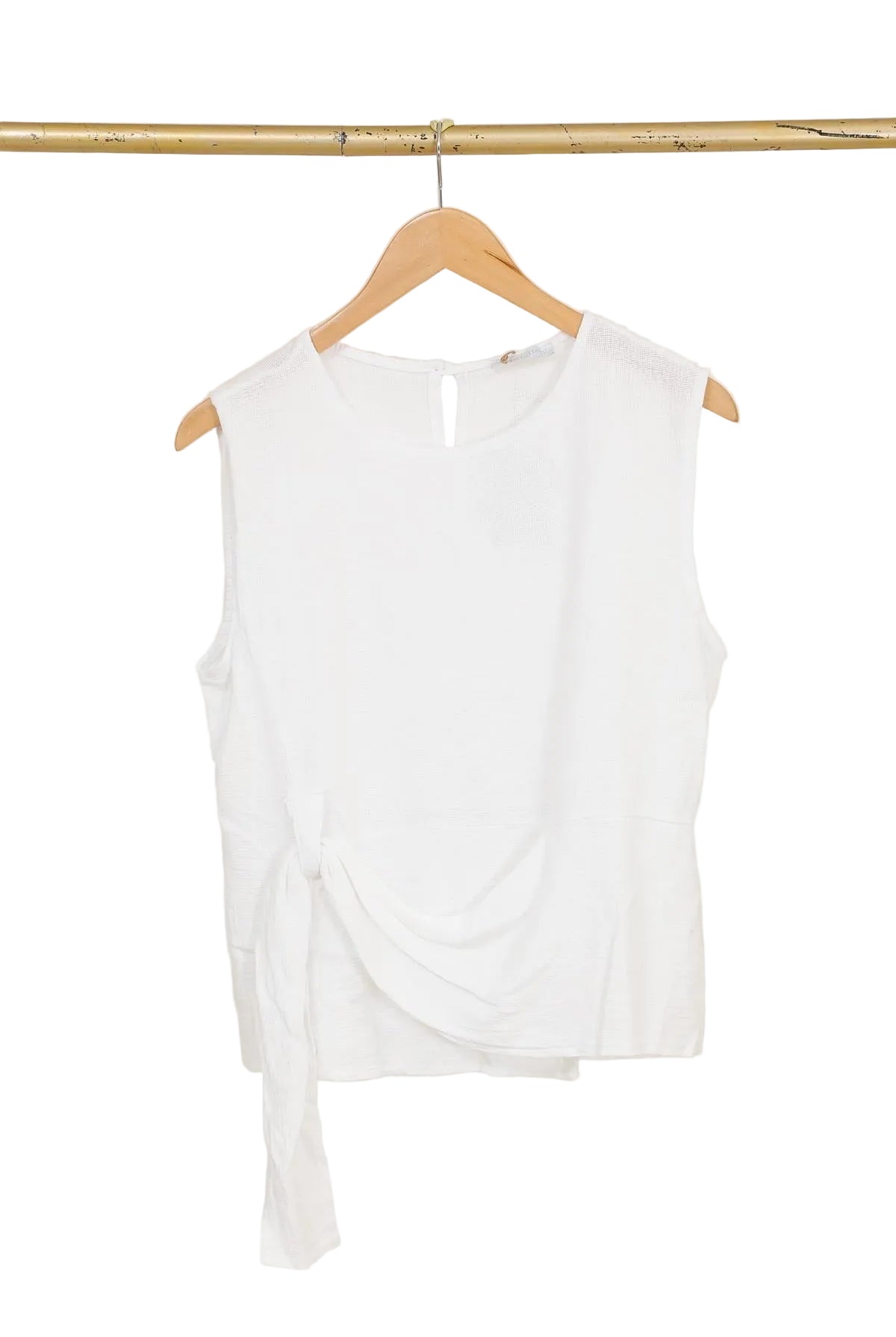 White sleeveless top on a wooden hanger against a white background
