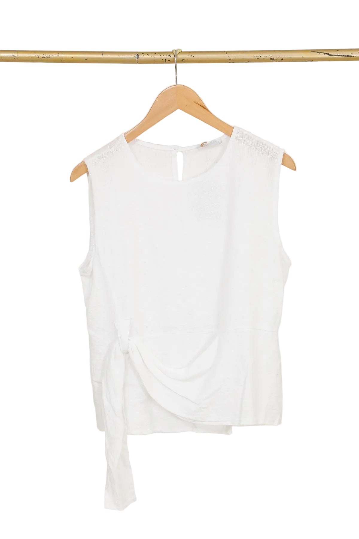 White sleeveless top on a wooden hanger against a white background