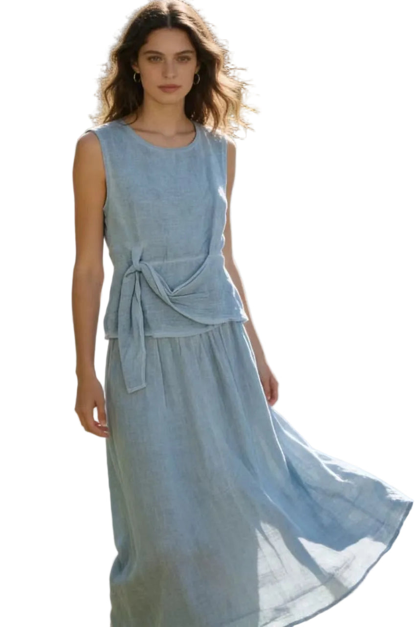 Woman in a blue jeans linen top & skirt with a white background