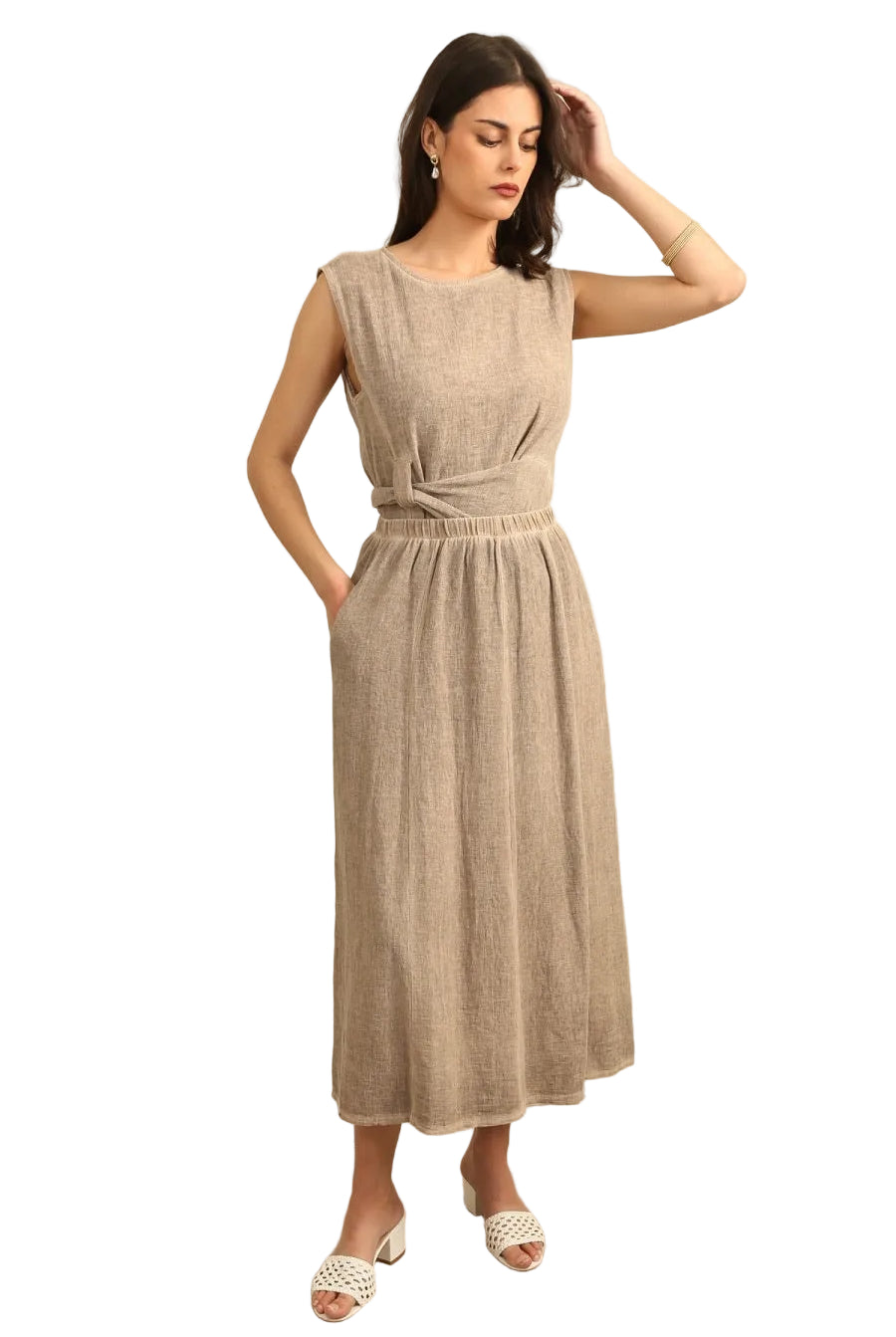 Woman in a taupe linen top & skirt with white background