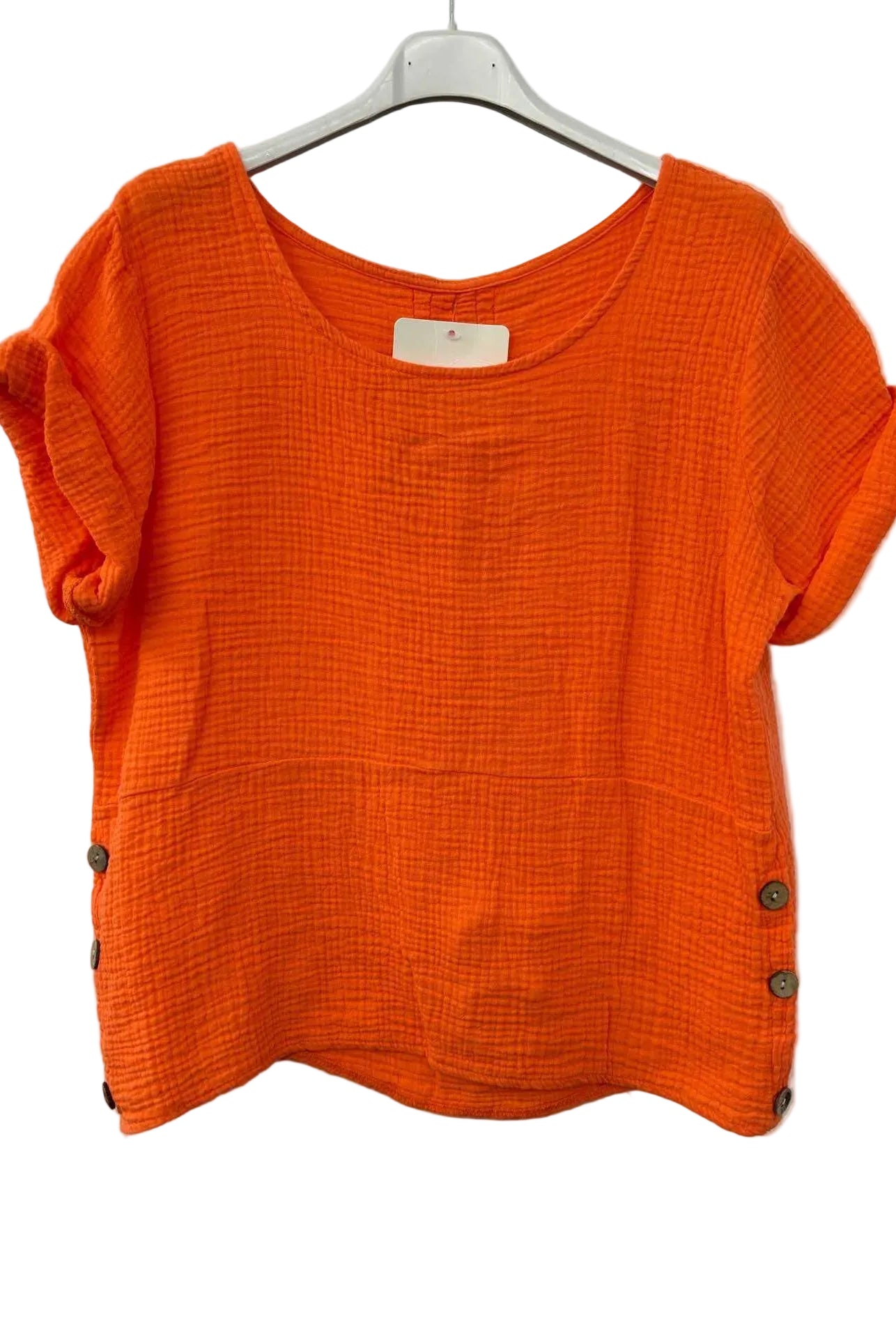 Orange textured top on a hanger against a white background