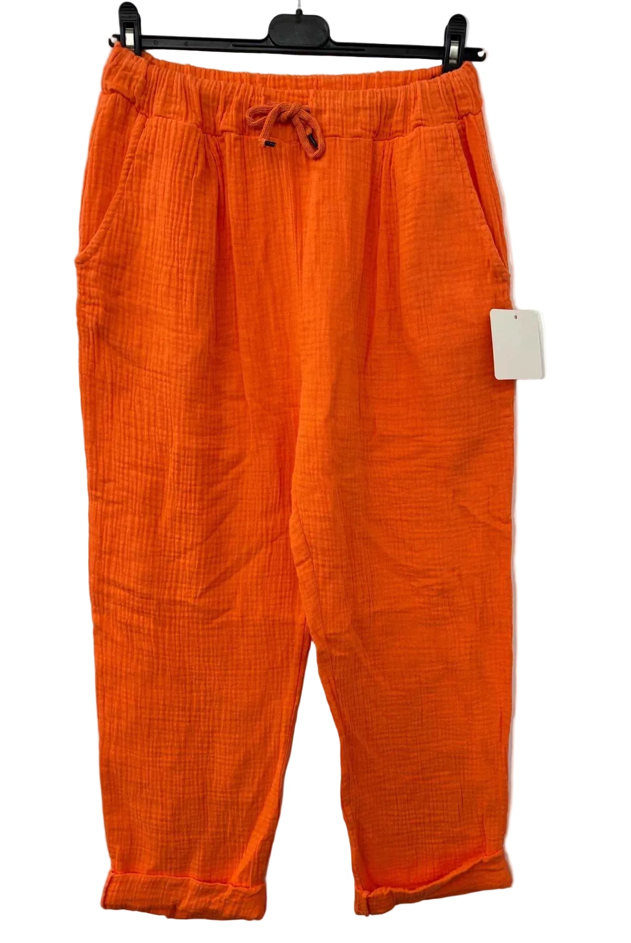 Orange pants with a tag on a white background