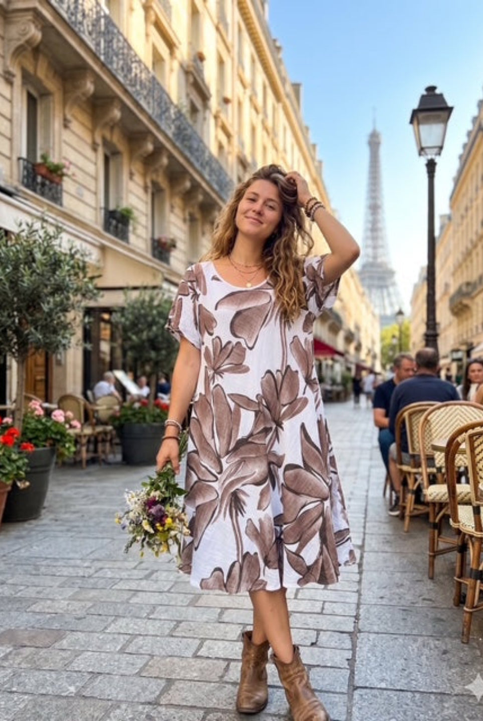 Woman in a floral dress standing on a Paris street with the Eiffel Tower in the background.