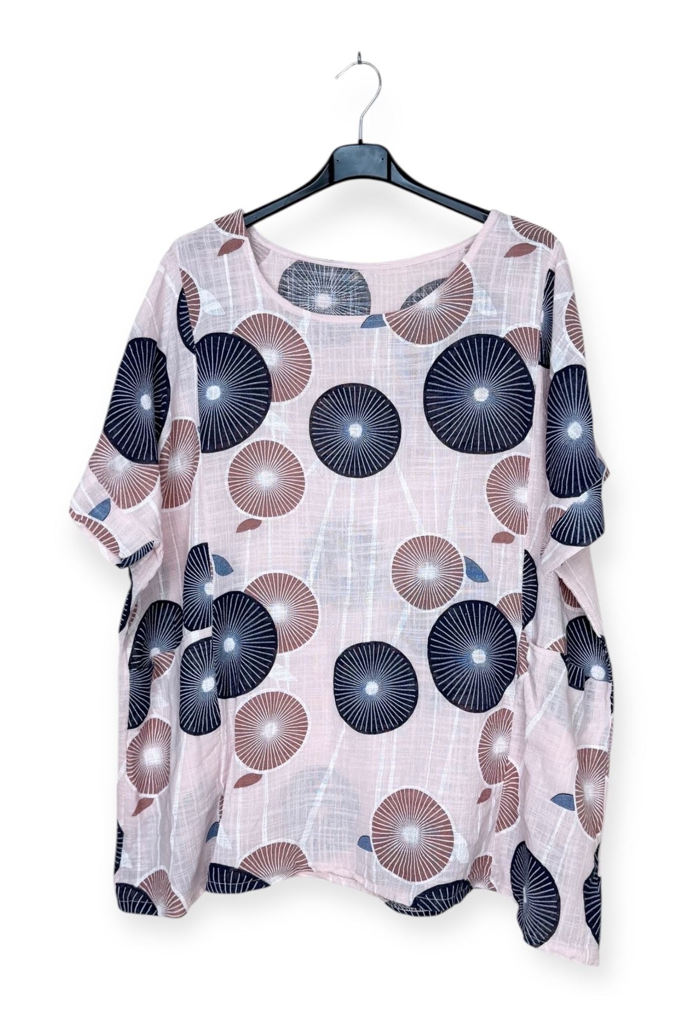 Floral patterned blouse on a hanger against a white background