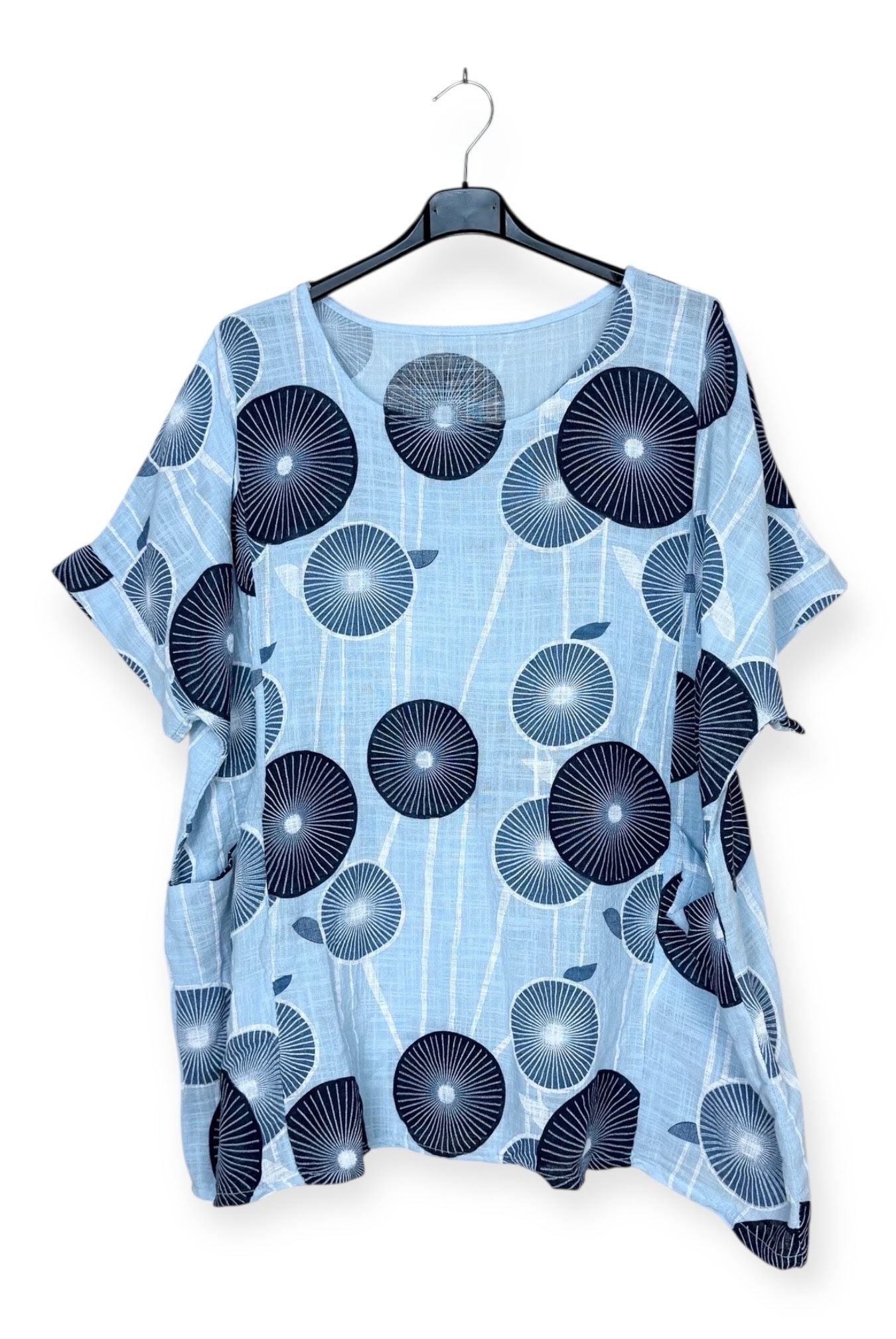 Blue shirt with black circular pattern on a hanger against a white background