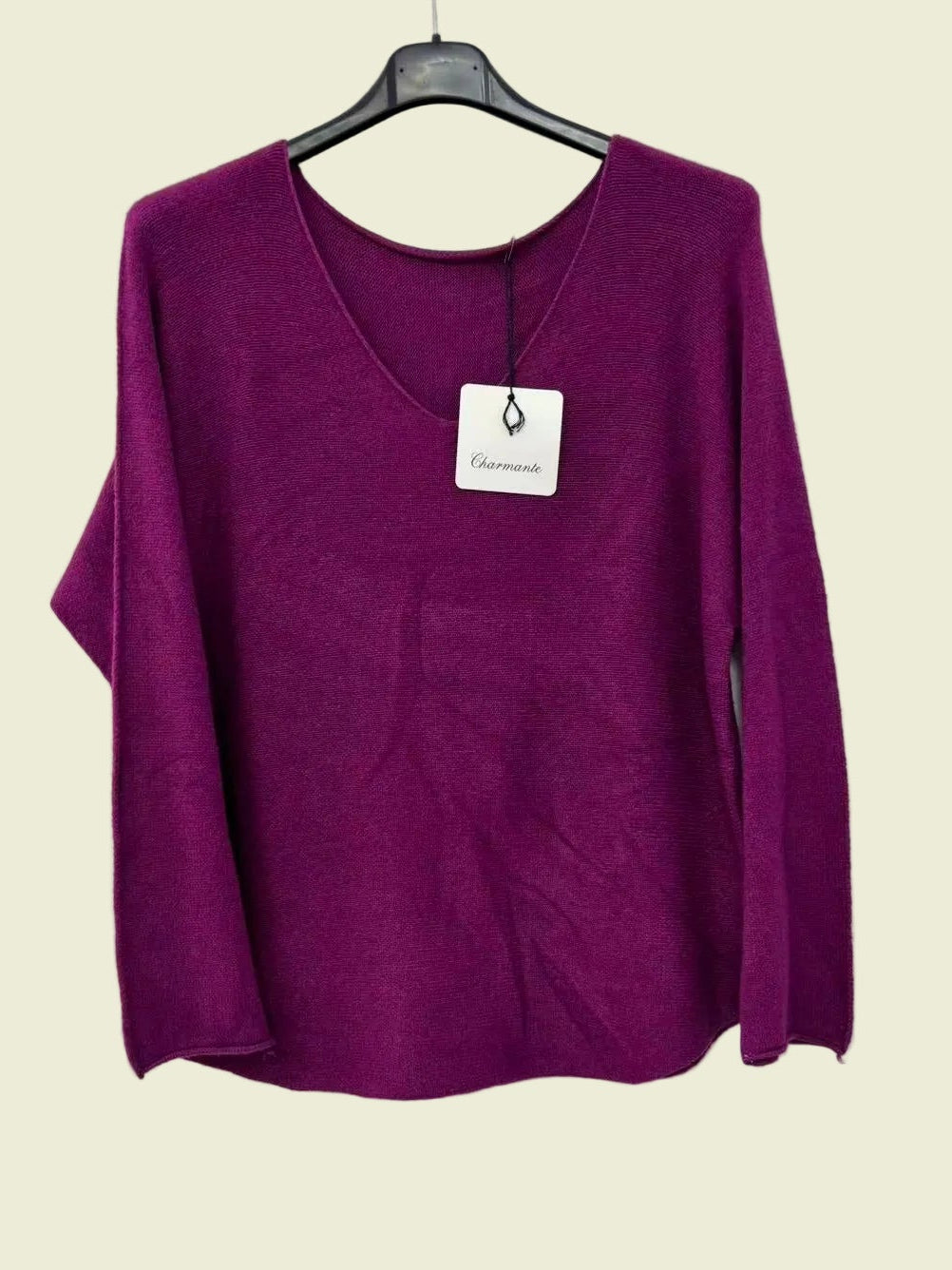A long-sleeve knit sweater in a rich magenta-purple color,