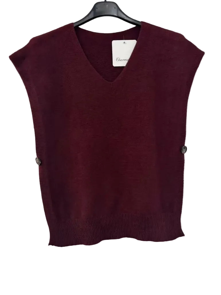 A sleeveless burgundy knit V-neck sweater vest hanging on a black hanger against a plain white wall.