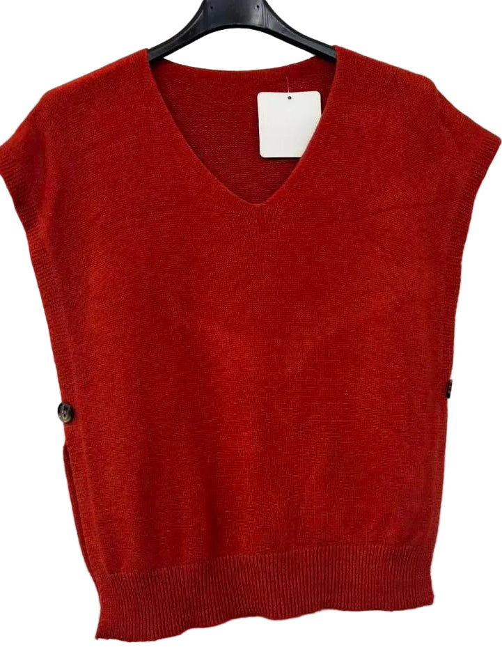 A brick coloured sleeveless V-neck knit sweater vest hanging on a black hanger against a plain white wall.