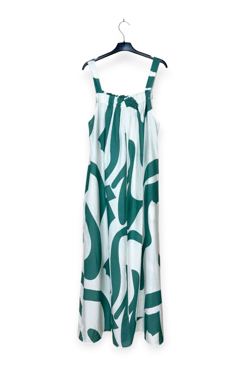 Turquoise and white patterned dress on a hanger against a white background