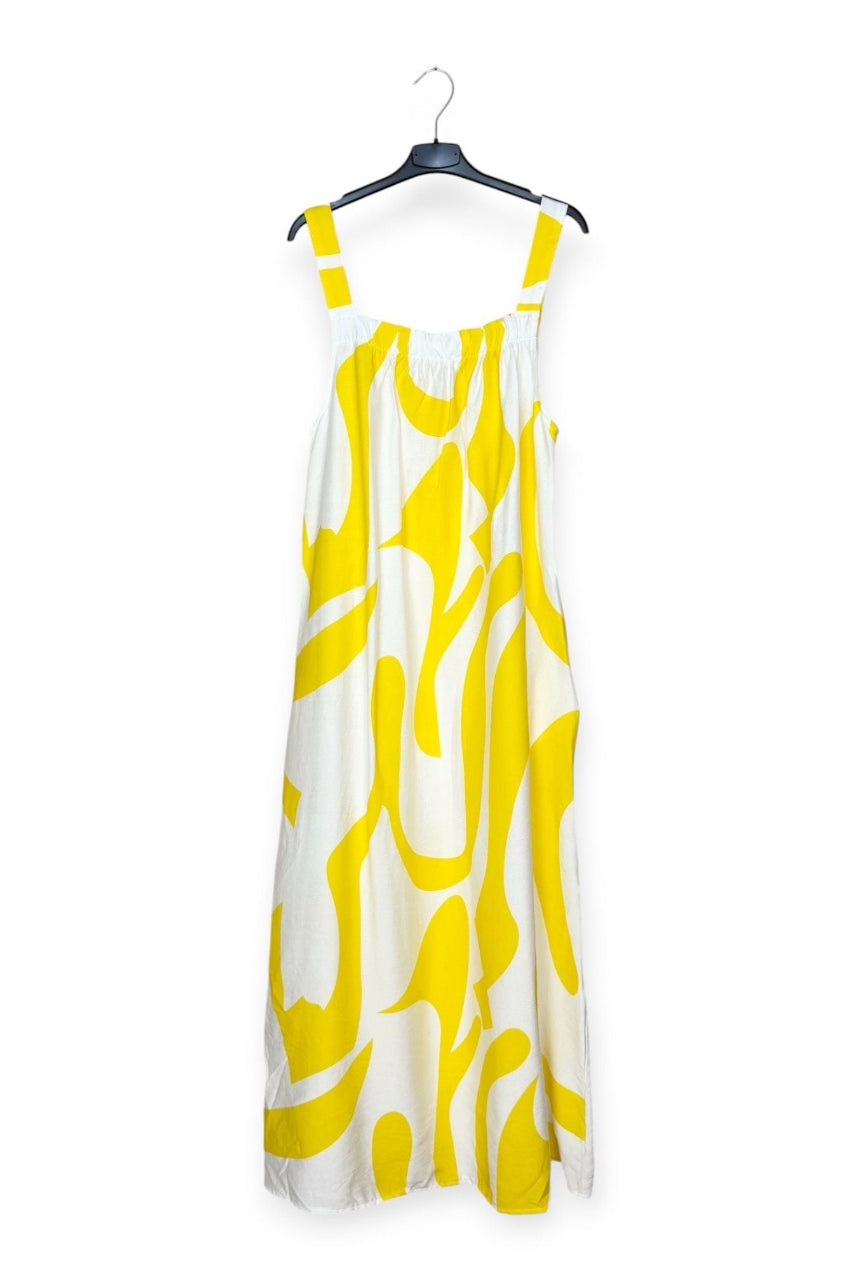 Yellow and white patterned dress on a hanger against a white background