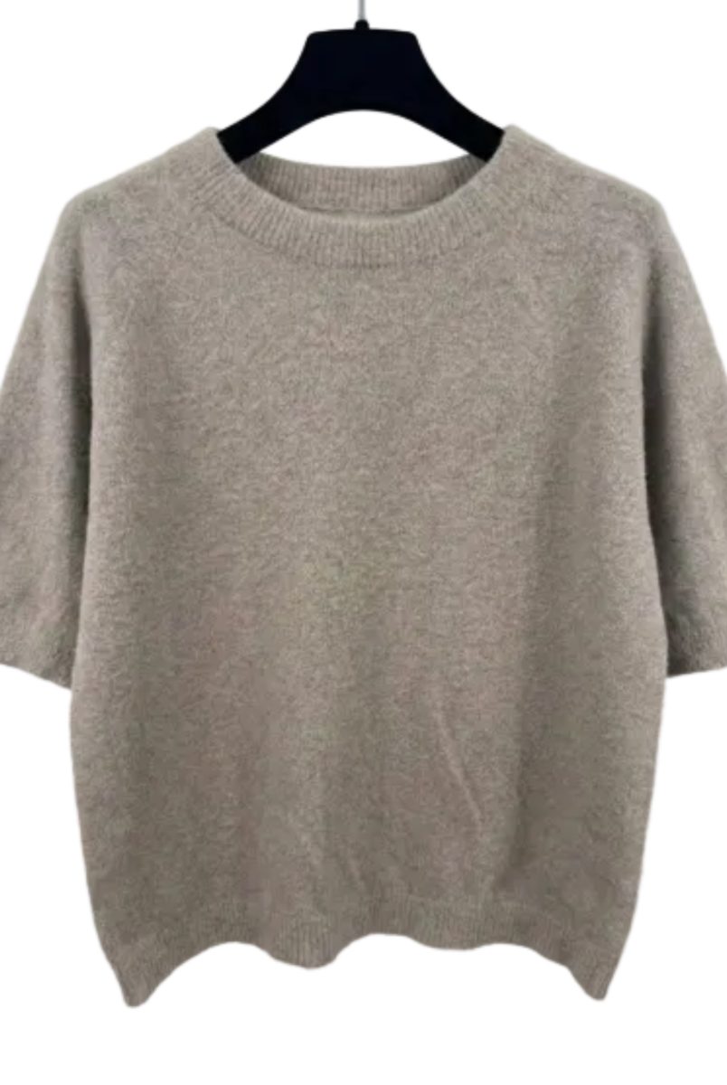 Beige sweater on a hanger against a white background