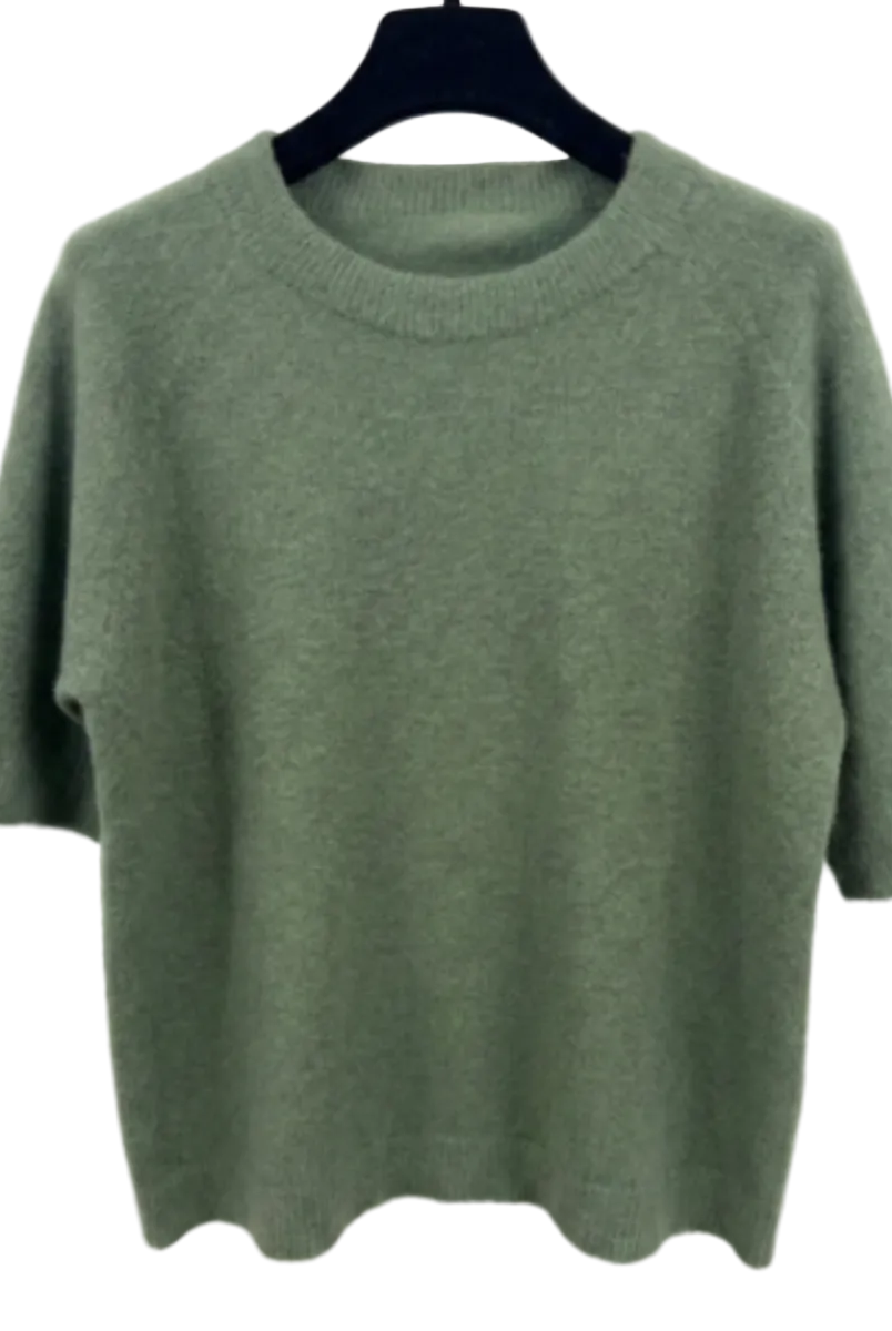 Green sweater on a hanger against a white background