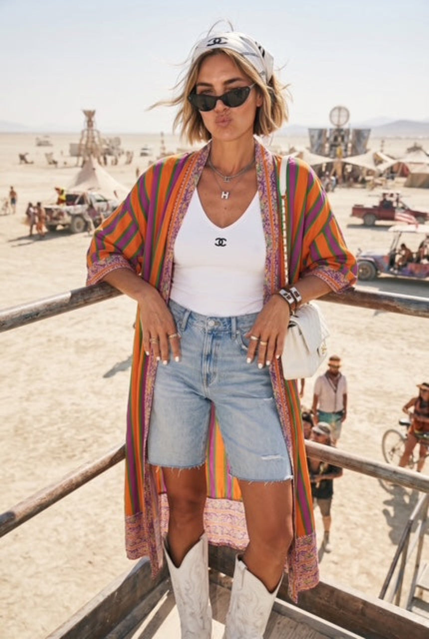 Woman in colorful kimono-style garment with denim shorts