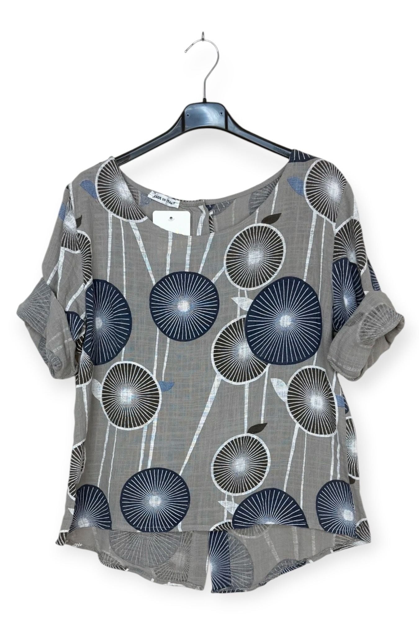 taupe top with blue floral pattern on a hanger against a white background