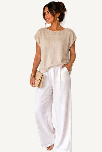 Woman wearing a beige top with a detailed neckline, surrounded by product details and brand name.