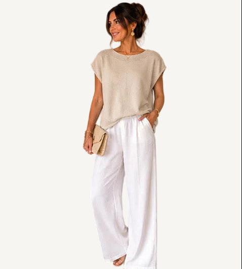 Woman wearing a beige top with a detailed neckline, surrounded by product details and brand name.