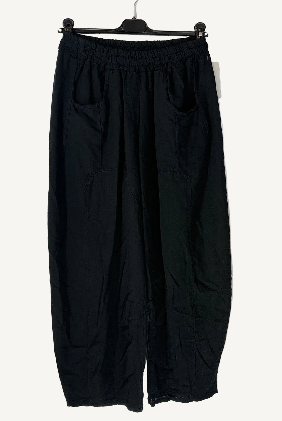 Black wide-leg pants on a hanger against a light background