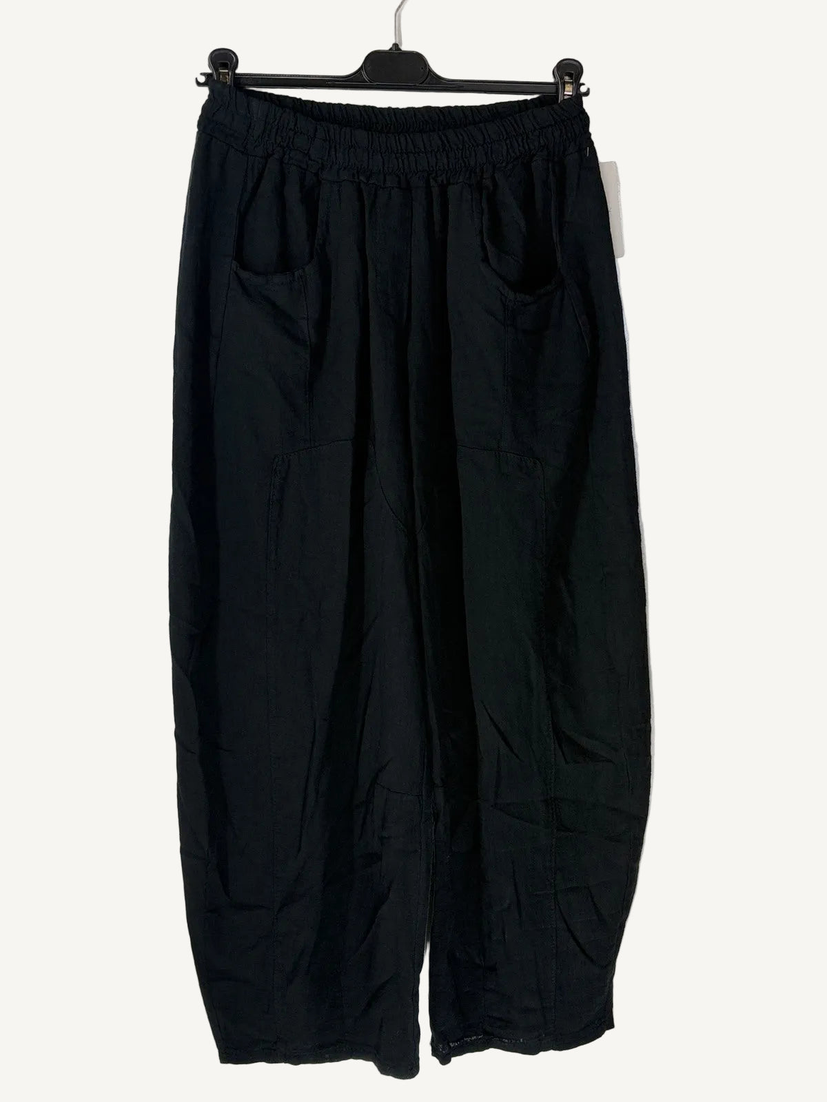 Black wide-leg pants on a hanger against a light background