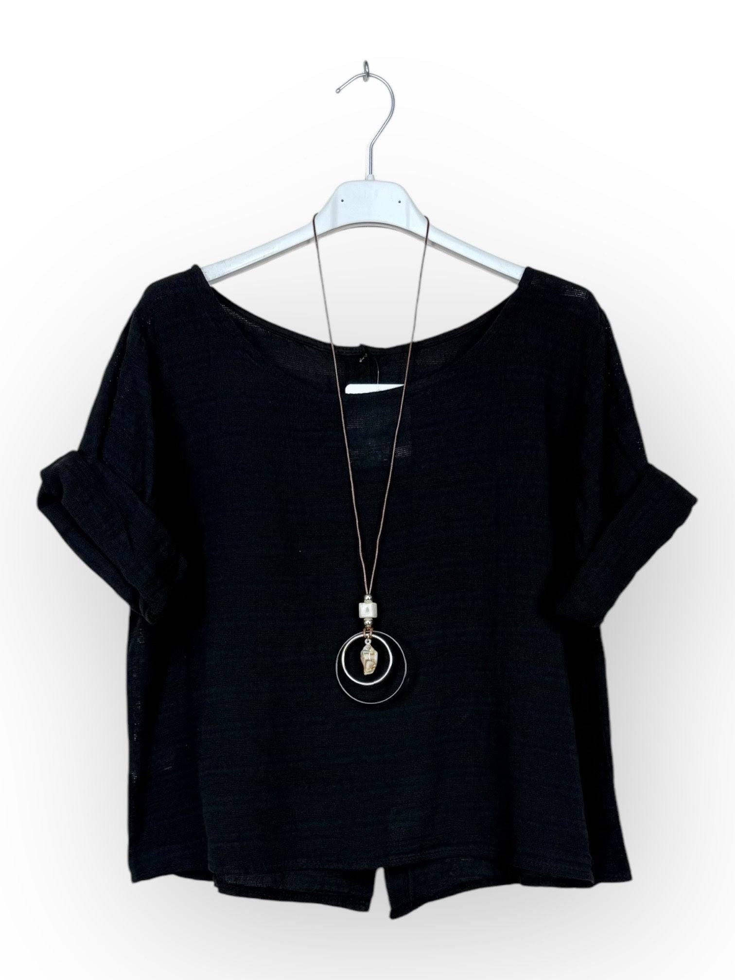 A black short-sleeve top with a wide scoop neckline, displayed on a white hanger with a long silver pendant necklace.