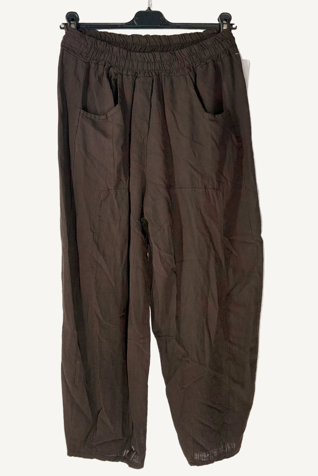 Brown pants on a hanger against a light background