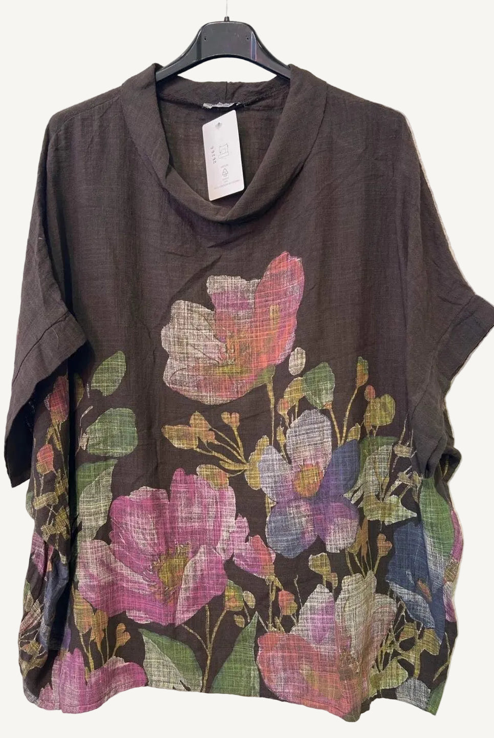 Brown top with floral patterns on a hanger against a white background