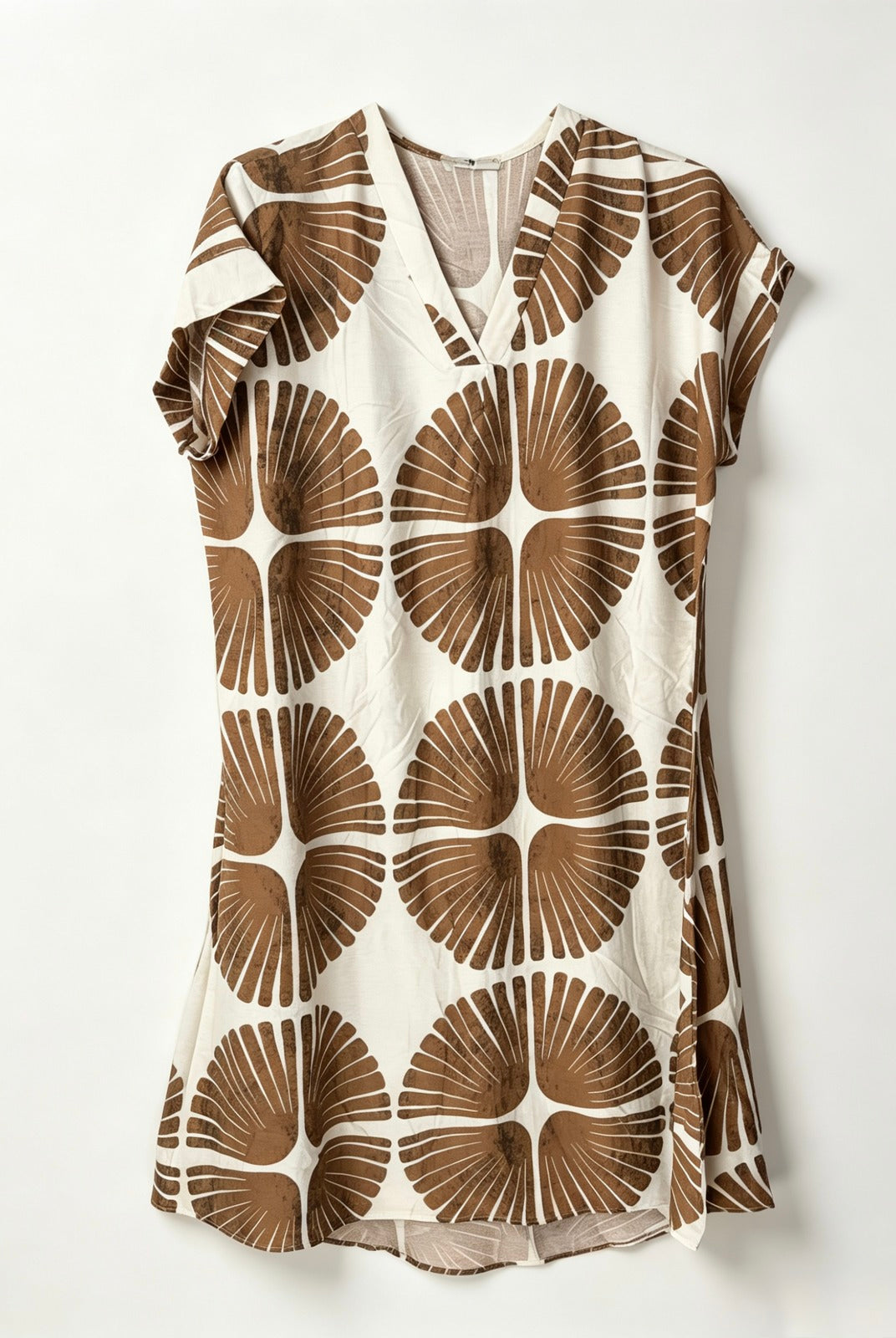 A short-sleeve V-neck dress featuring a bold brown and cream geometric floral pattern, displayed flat against a light off-white background.