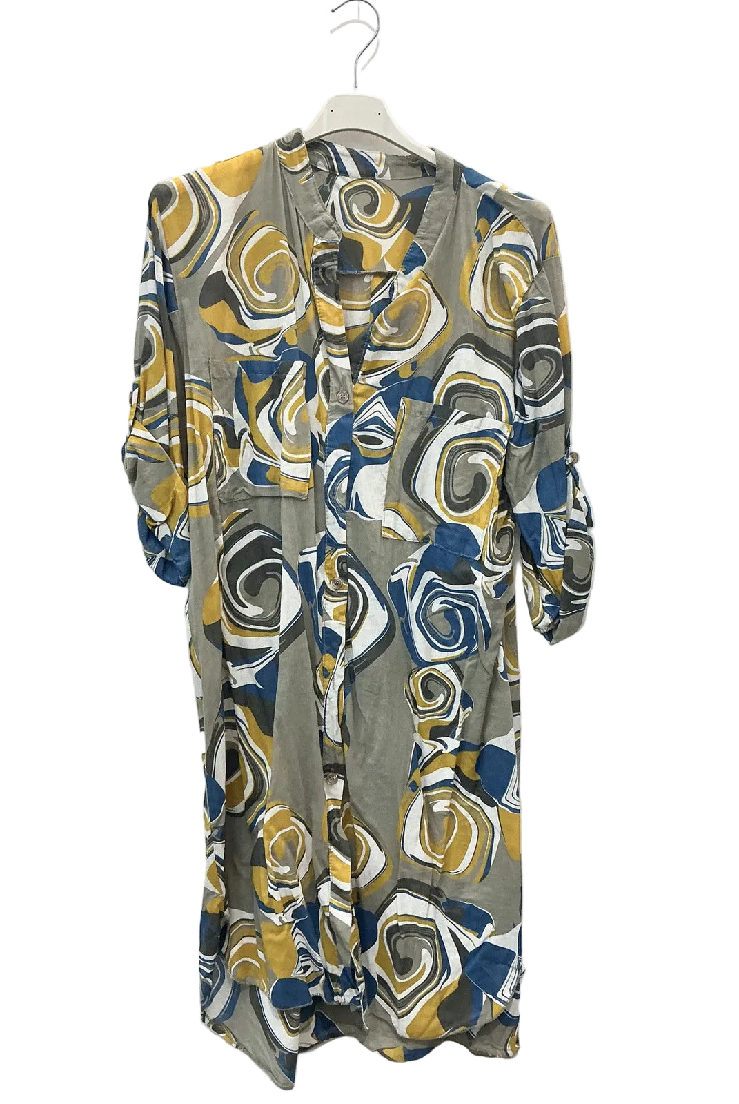 A long-sleeved button-up shirt dress with an abstract swirl pattern in gray, mustard yellow, navy blue, and white, hanging on a white plastic hanger against a plain white wall.