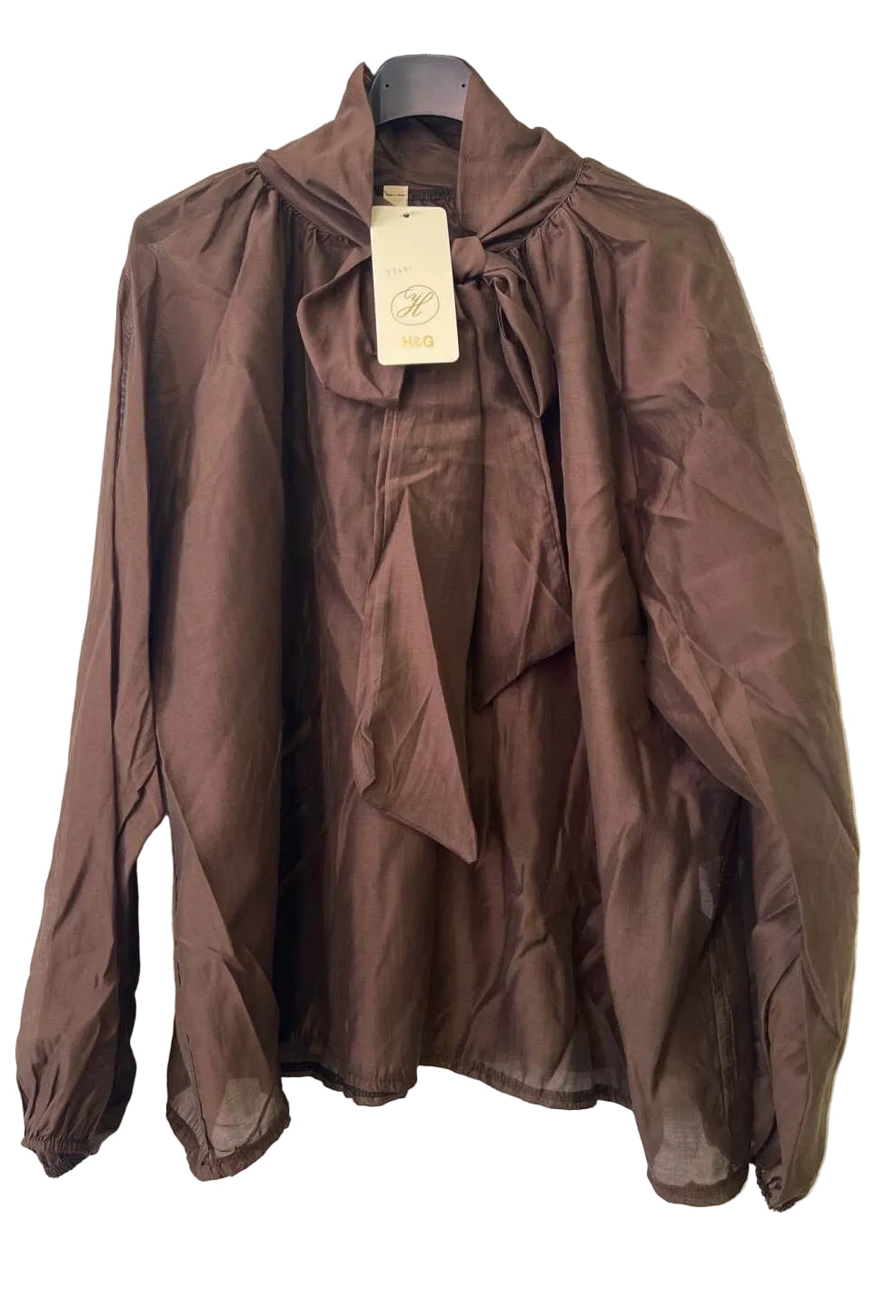 A brown long-sleeve blouse with a high gathered collar, front tie detail, and elasticized cuffs,
